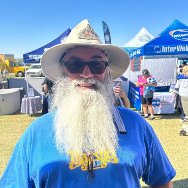 man with grey beard with hat and blue shirt